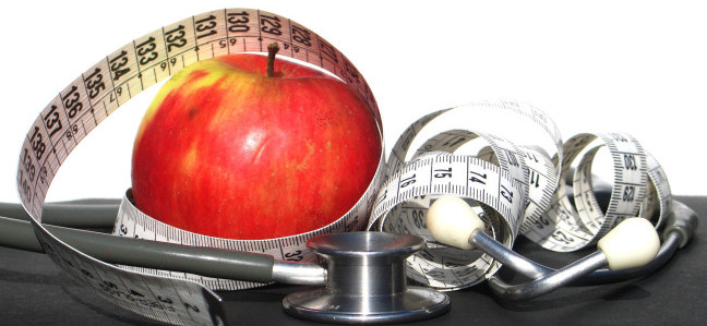 manzana roja, cinta métrico y estetoscopio